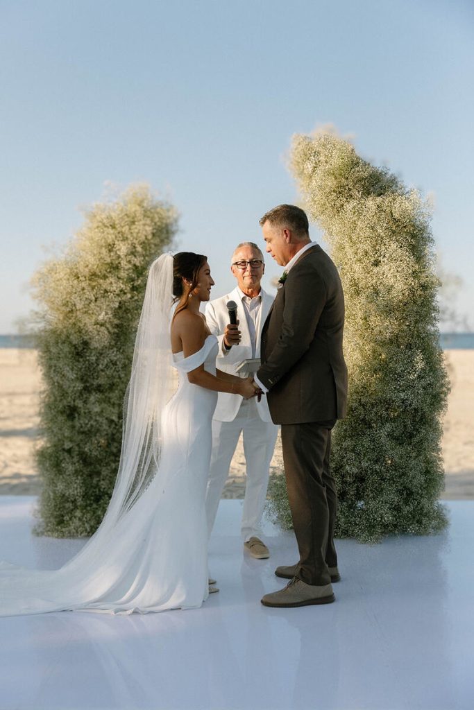 Mackenzie and Scott holding hands during wedding ceremony