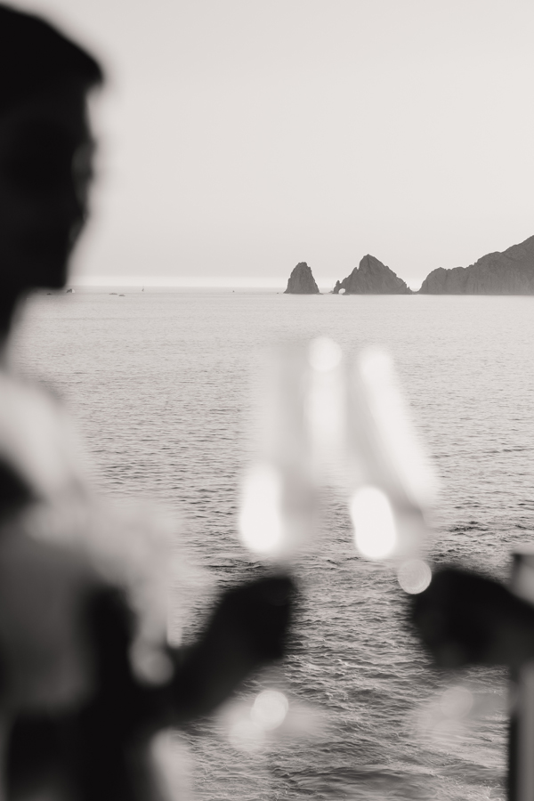 Couple making toast with Los Cabos Arch as Backdrop