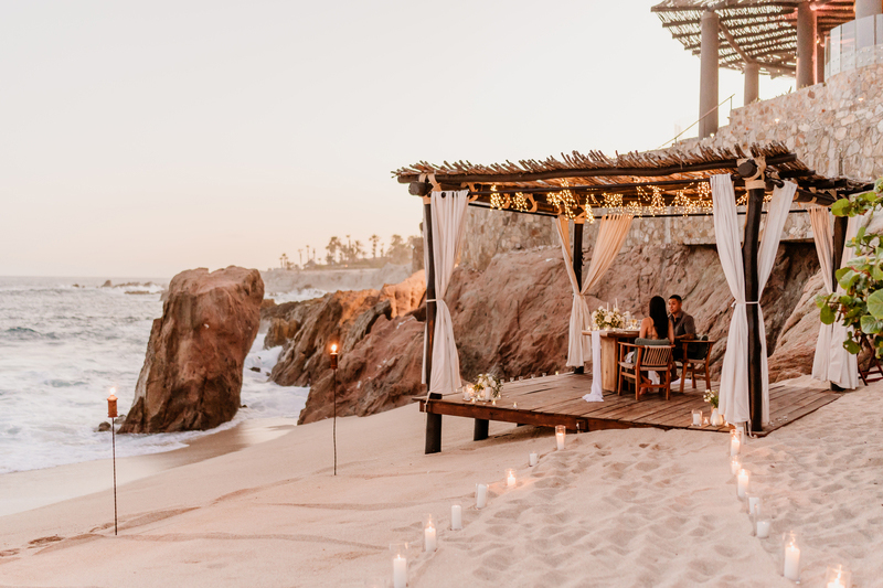 The newly engaged couple having dinner by the ocean