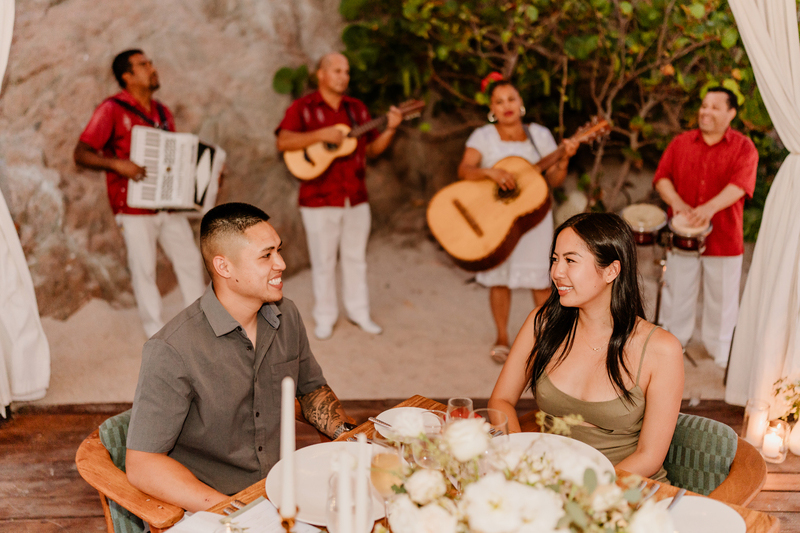 Casey and Kevin having dinner while musicians play live music