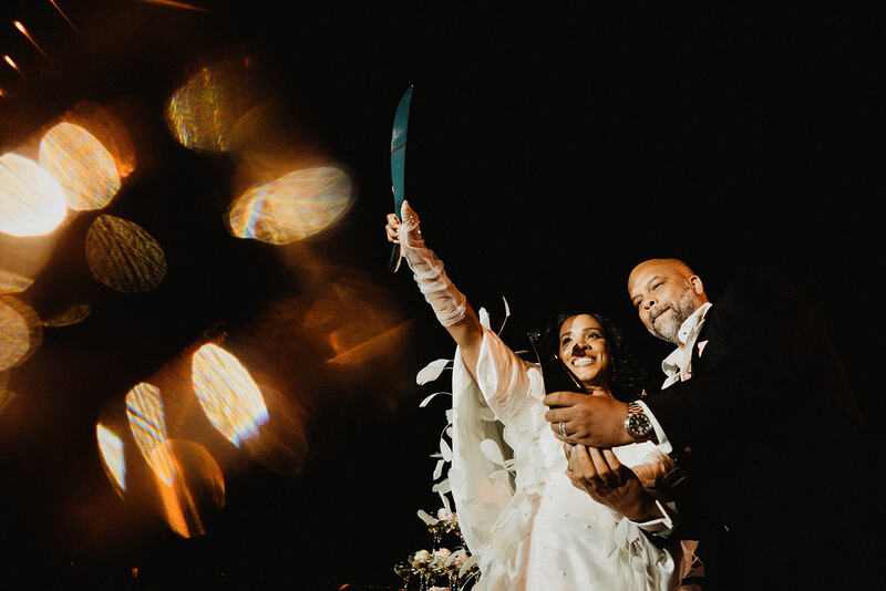 The newly weds opening a bottle of champaigne
