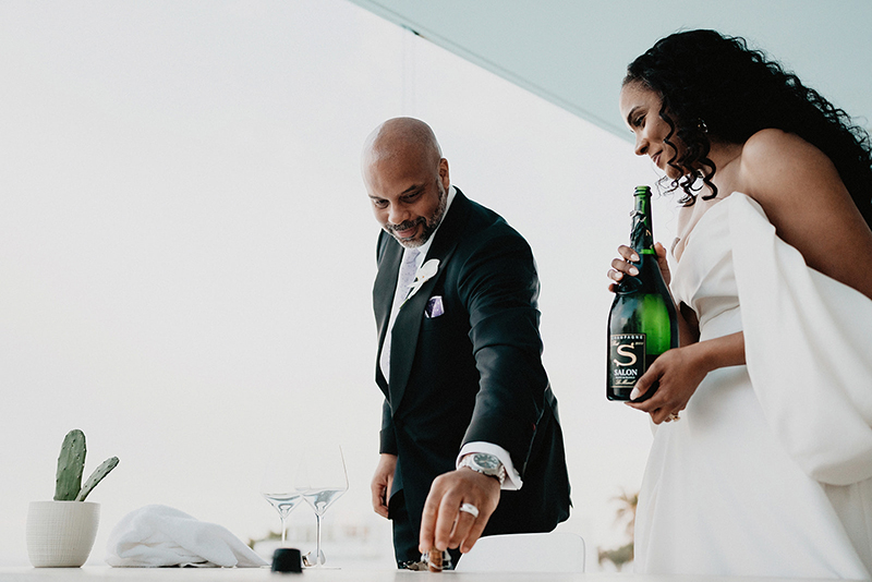 The newly weds having a bottle of wine