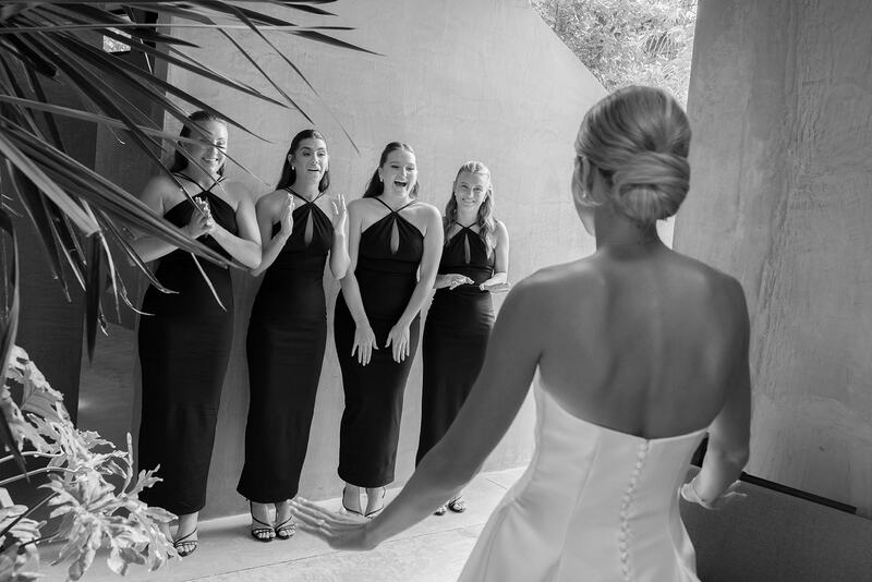 Bridemaids looking at Bella for the first time wearing her wedding dress