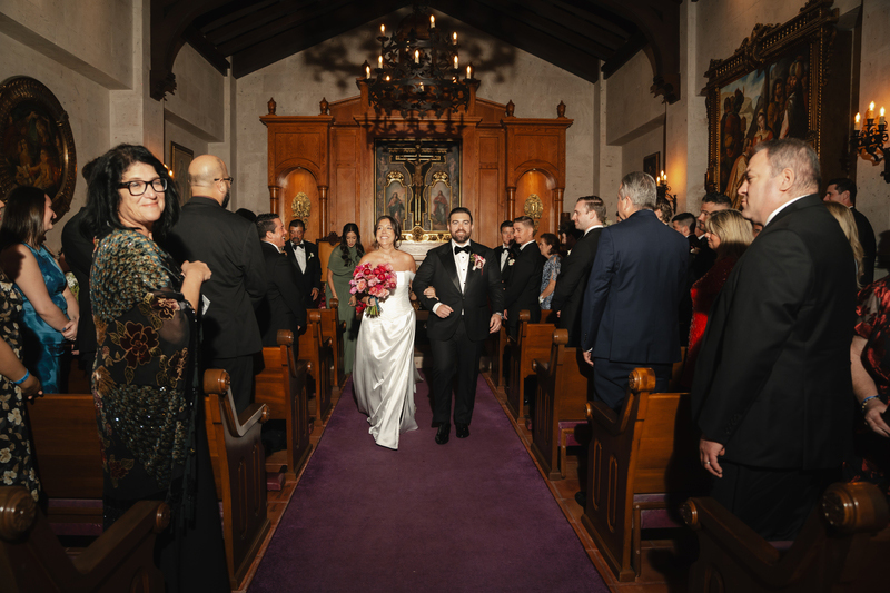 The newly weds walking down the chapel's aisle